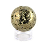 Polished pyrite sphere with craters on a white background.