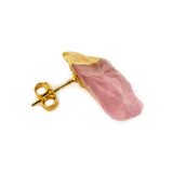 Side view of a single raw rose quartz stud earring in gold-tone setting showing stone texture and depth.