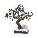 Large black onyx gemstone bonsai tree sculpture with amethyst crystal foundation.