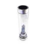 Gemini Laterra Gemstone Water Bottle with labradorite crystal attachment inside clear glass bottle on white background.