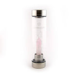 Laterra Gemstone Water Bottle with rose quartz crystal point insert inside clear glass bottle.