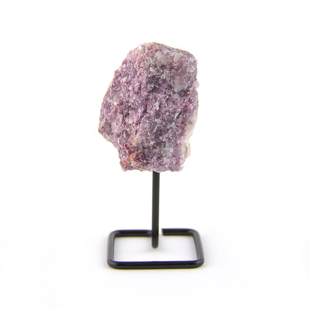 Raw lepidolite crystal on black metal display stand against white background.