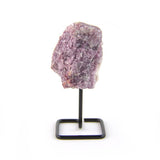 Raw lepidolite crystal on black metal display stand against white background.