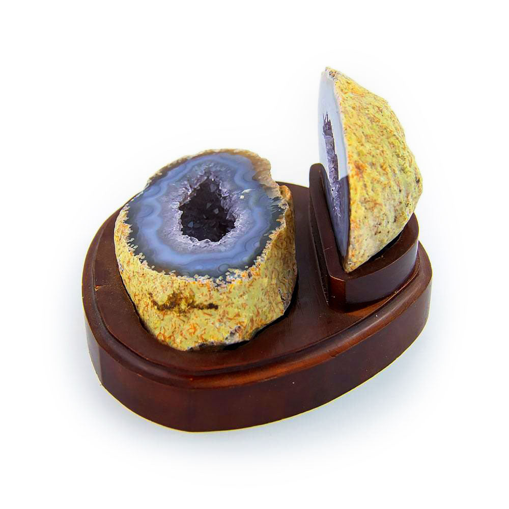 Agate geode on wooden display, angled view highlighting natural banding and crystal detail.