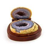 Split agate geode on wooden display, front view showing both halves and exposed crystal interior