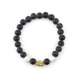 Top view of gold lion head beaded bracelet with black onyx and white howlite.