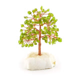 Front view of peridot gemstone tree with copper branches and white crystal base.