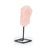 Raw rose quartz crystal on metal stand for home decor, left angled view against white background.