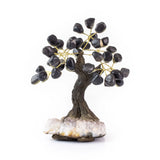 Small black onyx bonsai tree with polished gemstone leaves on amethyst crystal base.