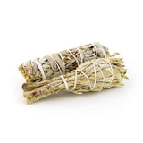 Two small sage smudge sticks on white background for cleansing and protection rituals.