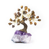 Small tiger eye bonsai tree with polished gemstone leaves on amethyst crystal base.